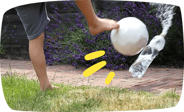 Wasserspiele für Kinder Kind kickt eine Wasserflasche 
